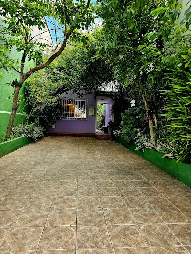 Fachada da clínica Espaço Presente com jardim e entrada roxa.